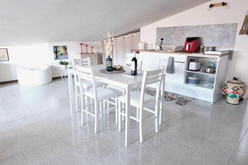 a white kitchen with a white table and chairs at O' Frechete! in Sulmona