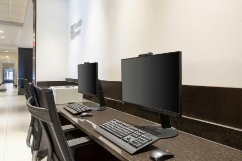 a desk with two computer monitors and a keyboard at Courtyard Worcester in Worcester