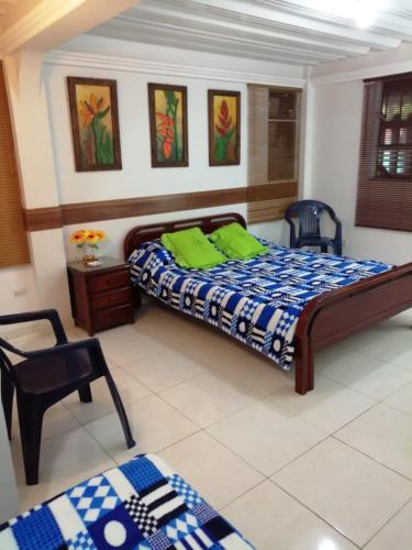a bedroom with a bed and a chair at Hostal las margaritas in Pasto