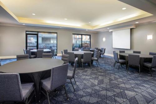a conference room with tables and chairs and a whiteboard at Courtyard Worcester in Worcester