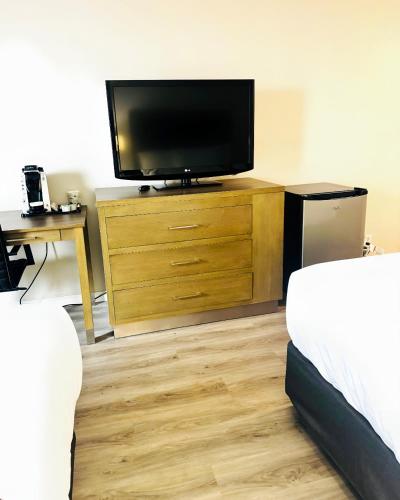 a room with a tv and a dresser with a television at Silver Beach Hotel in Saint Joseph