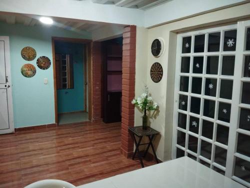 a room with a door and a vase of flowers on a table at Hostal las margaritas in Pasto