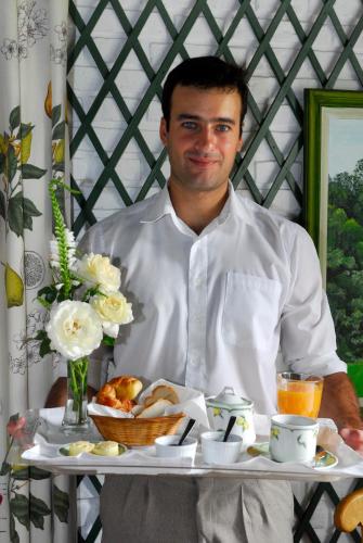 タンディルにあるEstancia Ave Maríaの食べ物を載せたトレイを持った男性