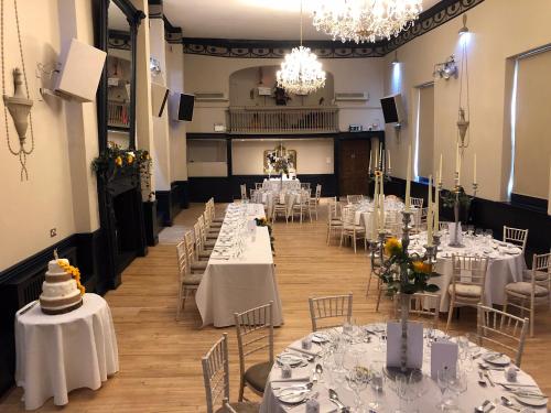 a room full of tables with white tablecloths at Crown Hotel in Nantwich