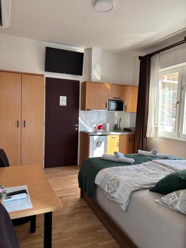 una camera da letto con un letto, un tavolo e una cucina di Apart AS a Mostar