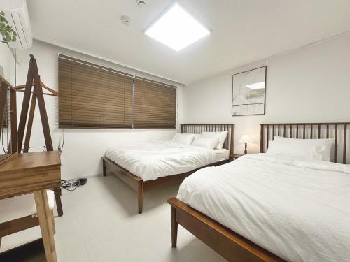 a bedroom with two beds and a piano at Check in Seoul Hongdae in Seoul
