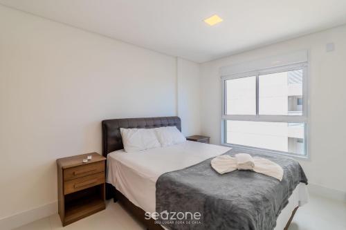 a bedroom with a bed and a window at Condomínio a beira-mar c/ piscina - SHC in Piçarras