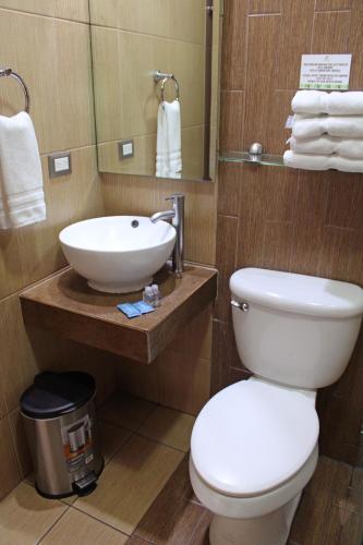 a bathroom with a white toilet and a sink at Terra Bella Hotel Boutique in San Salvador