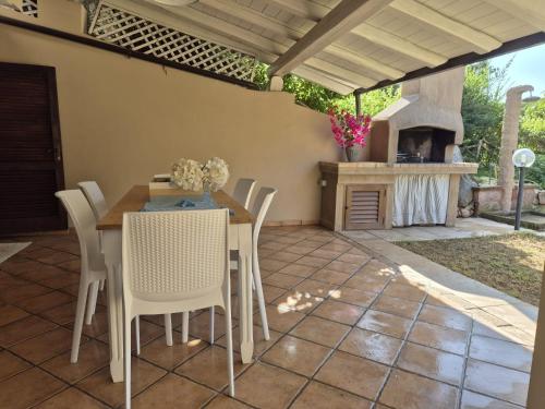 a patio with a table and chairs and a fireplace at Villasimius - Villa Sofia in San Stèfano