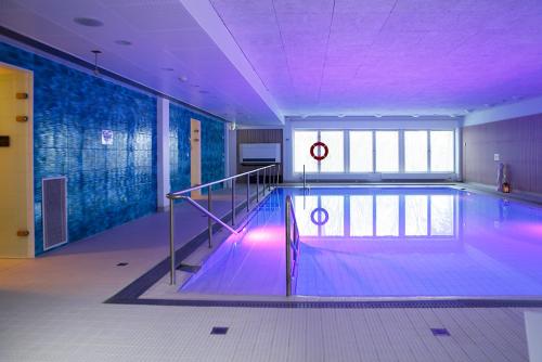 a swimming pool with purple lighting in a building at Meri-Karina in Turku