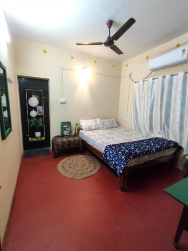 a bedroom with a bed and a ceiling fan at JeeHaa Homestay in Alleppey