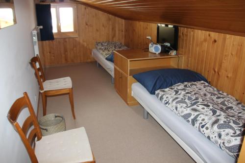 Cette petite chambre comprend un lit et un bureau. dans l'établissement Chalet Mittaghorn, à Adelboden