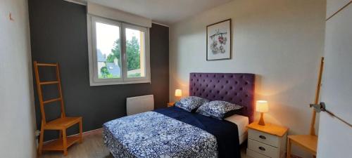 une chambre avec un lit bleu et une fenêtre dans l'établissement Pavillon individuel plain-pied avec terrasse et parking, à Saint-Vigor-le-Grand