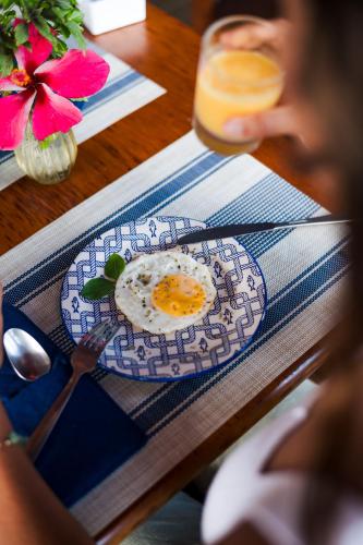 an egg on a blue plate on a table at Pousada Alto da Floresta Noronha by Alto da Ilha in Fernando de Noronha