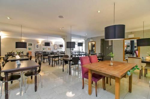 una sala da pranzo con molti tavoli e sedie di Coral Trade e Eventos prox a Pucrs, Araujo Vianna a Porto Alegre