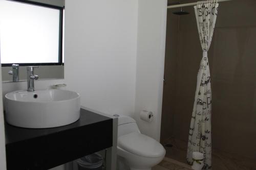 a bathroom with a white sink and a toilet at Pok Ta Pok Hotel in Cancún