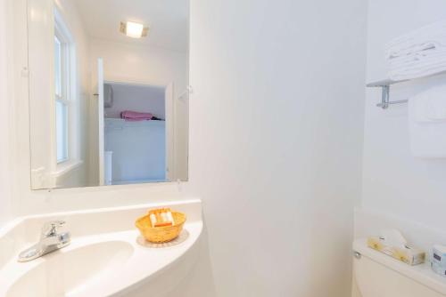 a white bathroom with a sink and a mirror at The Gull Oceanside Inn & Motel in Old Orchard Beach