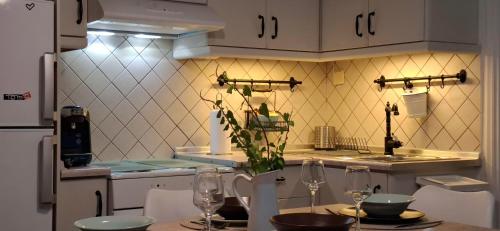 a kitchen with a table with wine glasses on it at Tenios Urban nest retreat in Kalamata
