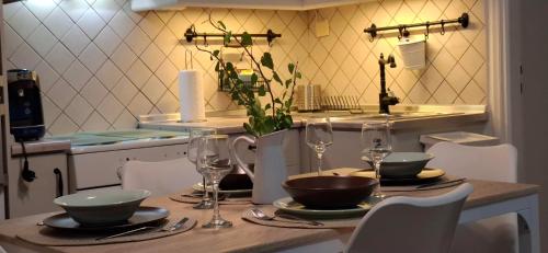 a table with plates and bowls and wine glasses at Tenios Urban nest retreat in Kalamata