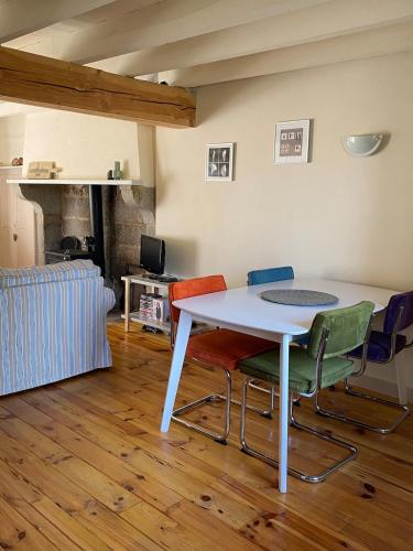 une table blanche et des chaises dans un salon dans l'établissement Gîte La Vie Verte, à Saint-Domet