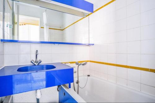 La salle de bains est pourvue d'un lavabo bleu et d'une baignoire. dans l'établissement Appartement 4/5 personnes vue mer piscine et montagne Cap Estérel Pierre et Vacance nature et sport, à Saint-Raphaël