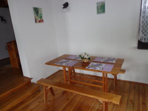 a wooden table and a bench in a room at Domek Letniskowy nad Jeziorem Tumiany in Bartołty Wielkie