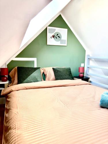 une chambre avec un lit dans un grenier dans l'établissement Escale du mont, à Pontorson