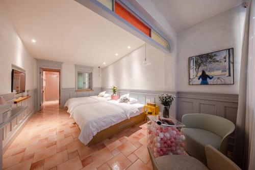 a large bedroom with two beds and two chairs at 杭州茶香丽舍旅居民宿 in Hangzhou