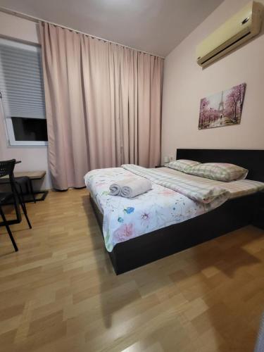a bedroom with a bed and a table and a window at Стаи за гости Пауза in Stara Zagora
