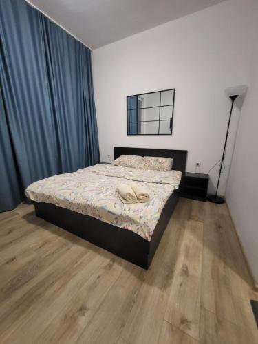 a bedroom with a bed and a wooden floor at Стаи за гости Пауза in Stara Zagora