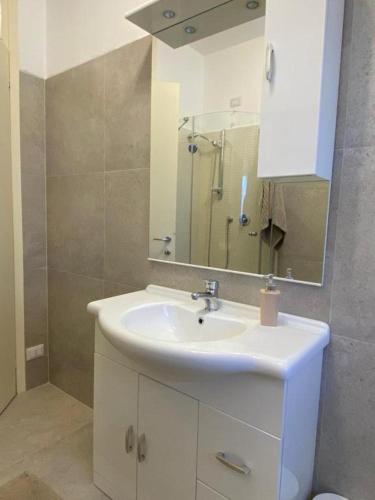 a bathroom with a white sink and a mirror at The Charme - Modern Apartment in Como with Balcony in Como