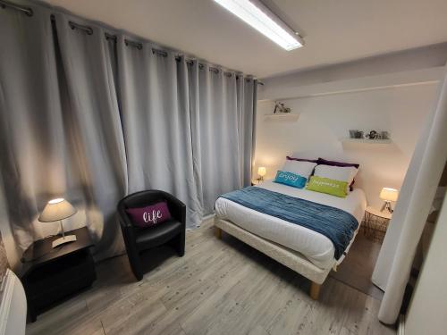 une chambre avec un lit et une chaise dedans dans l'établissement Hôtel du Commerce, à Ploeuc