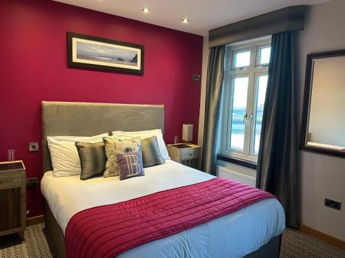 a bedroom with a large bed with a red wall at Harrys lounge in Whitby