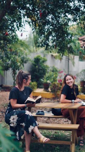 two women sitting at a picnic table reading books at Vrindavan homestay in Munroe Island