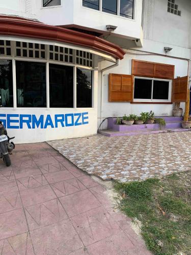 a building with a sign on the side of it at Germaroze in Oslob