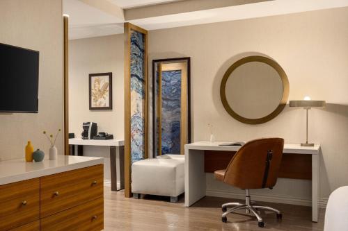 a hotel room with a desk and a mirror at Hotel Indigo Naperville Riverwalk by IHG in Naperville