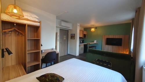 a small room with a bed and a kitchen at Logis Hôtel - Les Pasteliers in Lavaur