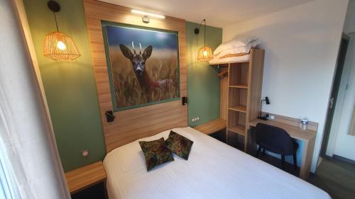 a bedroom with a bed and a painting of a deer at Logis Hôtel - Les Pasteliers in Lavaur