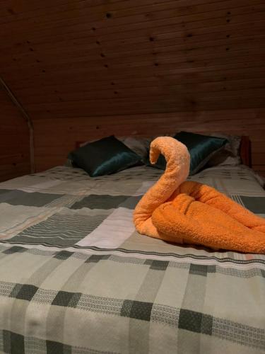 a bed with two orange snakes on top of it at Riverside Cabin in Železnička Stanica Ovčar Banja