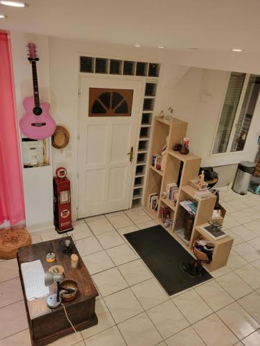 - un salon avec une guitare suspendue au-dessus d'une porte dans l'établissement Duplex dans havre de paix, sur le GR3 proche Loire et Canal, à Chécy