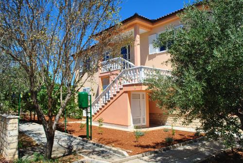 a house with a staircase in front of it at Apartmani Villa Dragica in Ugljan