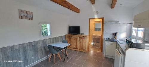 une cuisine avec une table et des chaises dans une pièce dans l'établissement Les Lauriers, à Saint-Christol-lès-Alès