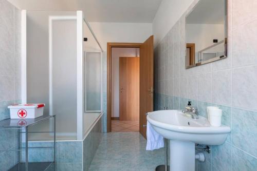 a bathroom with a sink and a mirror at Modern apartment with balcony-garage-and pool in Bellano