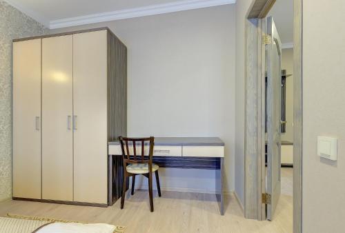 a room with a desk with a chair and a cabinet at Resident Hotel Almaty in Almaty