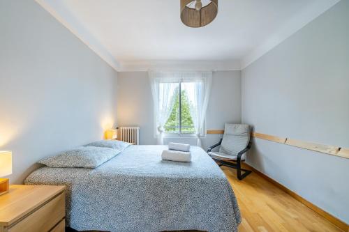 une chambre avec un lit, une chaise et une fenêtre dans l'établissement Appartement en plein coeur de Cagnes sur Mer, à Cagnes-sur-Mer