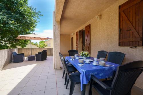 une table et des chaises bleues sur une terrasse dans l'établissement La Caletta Corsa Apartments con due camere a 100 m dal mare - WiFi fibra FTTH - ALL INCLUSIVE, à Linguizzetta