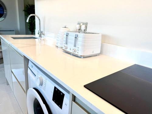 a kitchen counter with a washing machine on it at Cardiff Skyline Penthouse Apartment Free Parking Sleeps 8 in Cardiff
