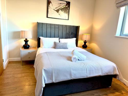 a bedroom with a large bed with two lamps at Cardiff Skyline Penthouse Apartment Free Parking Sleeps 8 in Cardiff