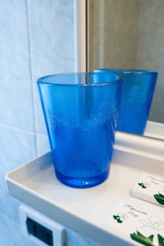 two blue cups sitting on a window sill at Hotel La Toscana in Arezzo
