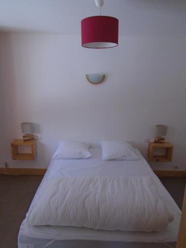 - une chambre avec un lit blanc et une lampe rouge dans l'établissement La Bartavelle, à La Giettaz